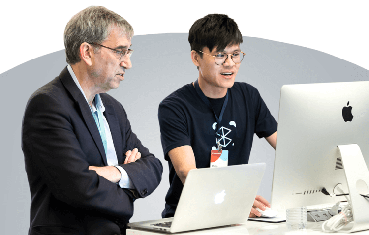 A Clio support agent helps a Clio Cloud Conference attendee at a computer.