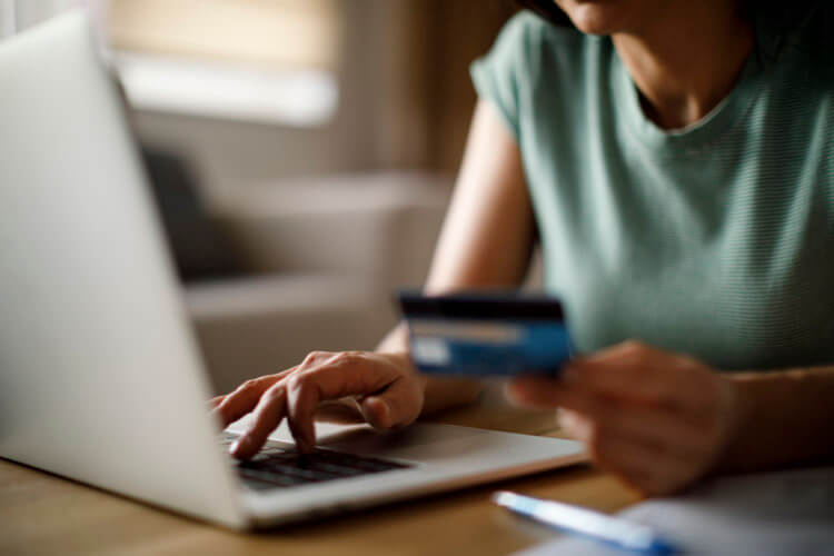 A photo of a lawyer holding a credit card and typing on a laptop A photo of a lawyer holding a credit card and typing on a laptop